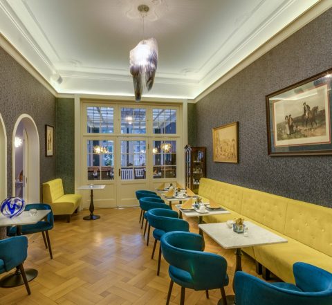 Cafe mit gelber Bank und blauen Stühlen, Jana Decker Raumgedanken